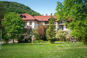una casa grande con un patio de hierba delante de ella en Bogolvar Retreat Resort, en Antalovtsi