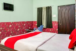 a bedroom with a large bed and a blue chair at Hotel Welcome Sri Vip Road Raipur in Phundardih