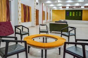 Zimmer mit Stühlen, einem Tisch und einem Tisch in der Unterkunft Hotel Welcome Sri Vip Road Raipur in Phundardih
