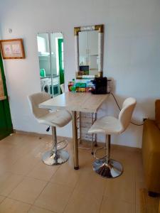 einen Tisch und zwei weiße Stühle in einem Zimmer in der Unterkunft Apartment Laura in Puerto Rico with ocean view free WiFi and Nespresso coffee in Puerto Rico de Gran Canaria