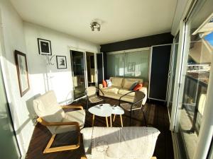 ein Wohnzimmer mit Stühlen, einer Couch und einem Tisch in der Unterkunft L'AZUREA Front de Mer in La Ciotat
