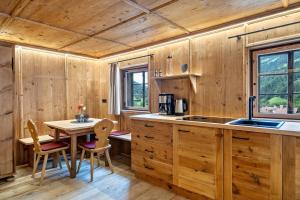 a kitchen with wooden walls and a table and chairs at Bergchalet Lanthalerhof in San Martino