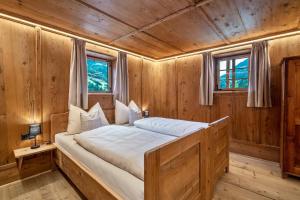 a bedroom with a bed in a wooden room at Bergchalet Lanthalerhof in San Martino