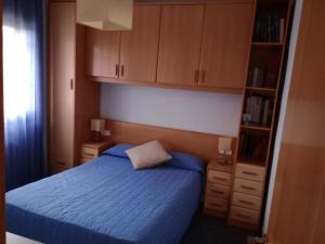 Schlafzimmer mit einem blauen Bett und Holzschränken in der Unterkunft Casa en Barcelona in Papiol