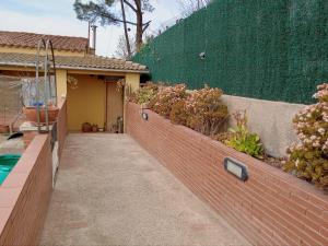 eine Backsteinmauer mit Pflanzen neben einem Haus in der Unterkunft Casa en Barcelona in Papiol