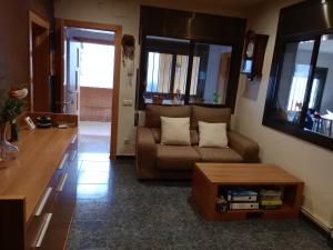 ein Wohnzimmer mit einem Sofa und einem Tisch in der Unterkunft Casa en Barcelona in Papiol