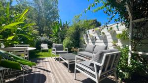 un groupe de chaises et de tables dans un jardin dans l'établissement Le Jardin Kerveguen, calme, confort et déco unique, Mer à 8 min, St Pierre-Tampon 400, à Le Tampon