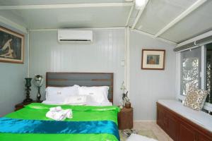 um quarto com uma cama verde e uma janela em Golden V Grandeuria Unit F em Malolos