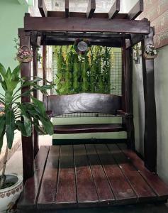 uma cadeira de madeira num quarto com uma planta em Golden V Grandeuria Unit F em Malolos