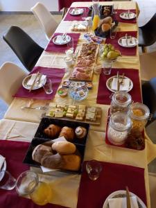 a long table with plates of food on it at Foresteria B&B Vecchiascuola Pianazzola in Chiavenna