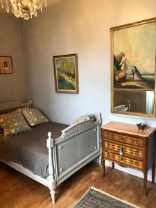 a bedroom with a bed and a dresser and a mirror at LA FERME DU PAVILLON in Sainte-Croix-du-Mont