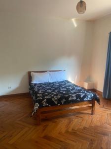 a bed in a room with a wooden floor at House 16 - Kweli and Kael in Chavanine