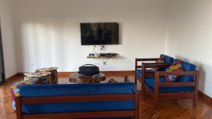 a living room with a blue couch and two chairs at House 16 - Kweli and Kael in Chavanine