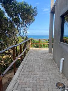 a walkway leading up to a house with the ocean in the background at House 16 - Kweli and Kael in Chavanine