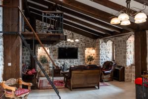 een woonkamer met meubilair en een televisie bij Talići Hill - Rustic Villas in Sutomore