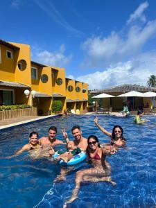 un gruppo di persone nella piscina di un resort di Casa e Conforto na Praia de Imbassaí a Imbassai