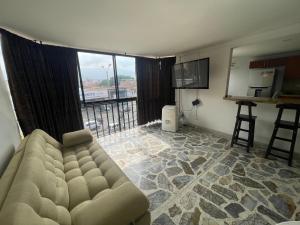 a living room with a couch and a large window at Apartamento cómodo , grande , céntrico , bien ubicado apto 303 in Medellín