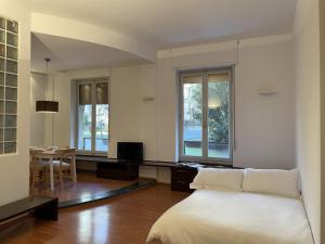um quarto com uma cama, uma mesa e janelas em Accomodo MIB52 Bivano Porta Genova em Milão