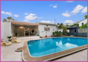 a swimming pool in front of a house at The Grand Queenslander On Turner in Aitkenvale