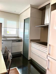 a kitchen with white cabinets and a table and chairs at Apartamentos las Palmas VII Family only in Salou