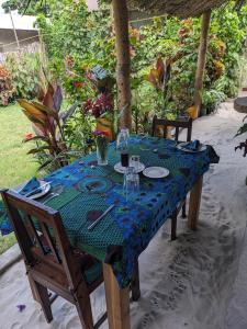 uma mesa com uma toalha de mesa azul em cima em kua garden cottage em Utende