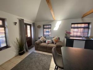 a living room with a couch and a table at The Old Stables in Mews in Kessingland