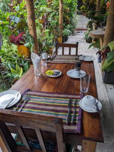 a wooden table with plates and utensils on it at kua garden cottage in Utende