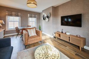 a living room with a table and a tv at Host & Stay - Baxtergate Apartments in Whitby