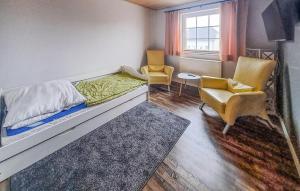 ein kleines Zimmer mit einem Bett und zwei Stühlen in der Unterkunft Lovely Home In Arendsee With Kitchen in Arendsee