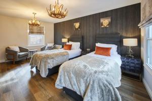 a hotel room with two beds and a chair at Host & Stay - Baxtergate Apartments in Whitby