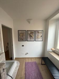 um quarto com uma banheira e quatro fotografias na parede em APPARTAMENTO SUITE SARDINIA HOLIDAY em Cagliari