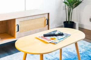 - une table en bois avec un magazine en haut dans l'établissement Brand New Modern One Bed Cradley Heath - Top Rated - 1MH, à Smethwick