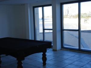 a room with a piano in front of two windows at Marina towers in Herzliya