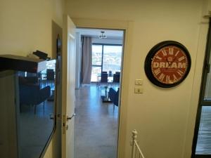 a clock hanging on a wall in a room at Marina towers in Herzliya