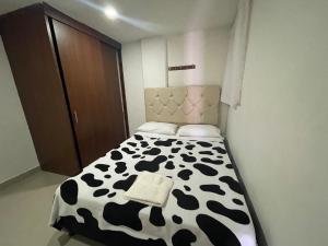1 dormitorio con 1 cama con estampado de vaca en blanco y negro en Apartamento cómodo , grande , céntrico , bien ubicado apto 303, en Medellín