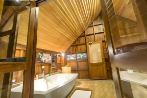 a bathroom with a large tub and a wooden ceiling at Glamping Wilpattu by Thamaravila in Wilpattu