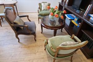 a living room with chairs and a table with a vase of flowers at Le Pavillon Lorrain in Vittel