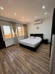 a bedroom with a bed and two windows at Lilly Rooms and Studio in Hurghada