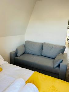 - un canapé dans une pièce à côté de 2 lits dans l'établissement Cozy Studio in Maidstone Town Centre, à Kent