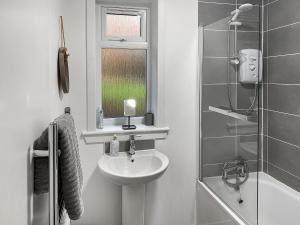 a white bathroom with a sink and a shower at Rhuside in Campbeltown