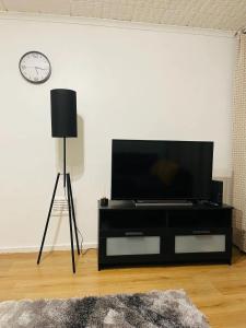 a black entertainment center with a flat screen tv on a wall at Well-preserved cozy1BR flat in LCY with free parking in London