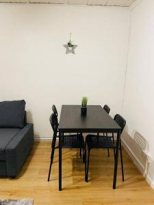 mesa de comedor negra con sillas y sofá en Well-preserved cozy1BR flat in LCY with free parking en Londres