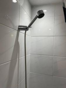 a shower with a shower head in a bathroom at Well-preserved cozy1BR flat in LCY with free parking in London