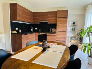 comedor con mesa de madera y cocina en La maison du Groove, en Trois-Ponts