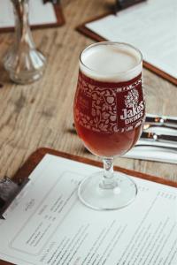 a glass of beer sitting on top of a table at The Woolpack Hotel in Tenterden