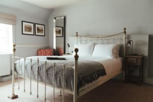 a bedroom with a white bed and a mirror at The Woolpack Hotel in Tenterden