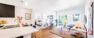 uma cozinha e sala de estar com paredes brancas e pisos de madeira em H4N Furnished Apartments Near JBLM em Lakewood