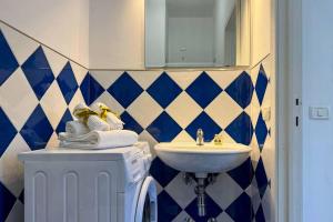 ein Bad mit blau und weiß gefliesten Wänden und einem Waschbecken in der Unterkunft [300m mare] Wifi taxi boat 2 Sorelle e relax in Numana