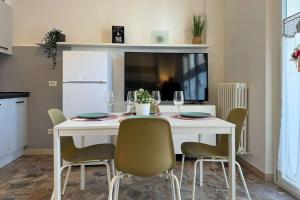 uma mesa de jantar branca com cadeiras e copos de vinho em [300m mare] Wifi taxi boat 2 Sorelle e relax em Numana mais 9 fotografias