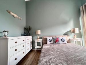 a bedroom with a bed with a dresser and two lamps at Apartament Łeba Piaskowa Ostoja in Żarnowska